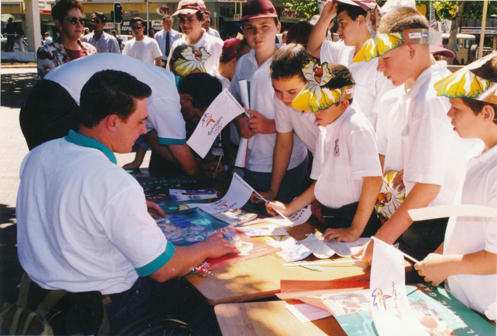 PRS118_091_001: Athlete signing autographs at Paralympic Expo in Church Street Mall, Parramatta, 1997 (City of Parramatta Council Archives)